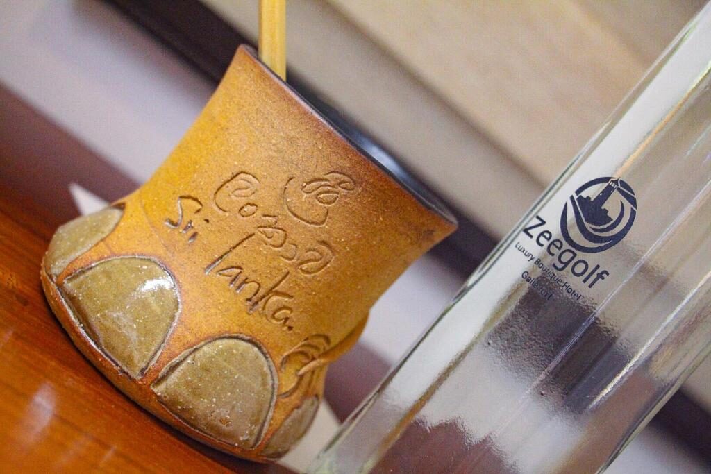 Ceylon clay tea cup beside a Zeegolf glass water bottle