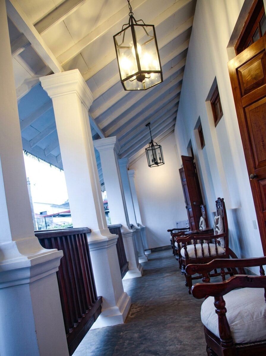 Upper verandah with hanging lanterns and carved teak chairs